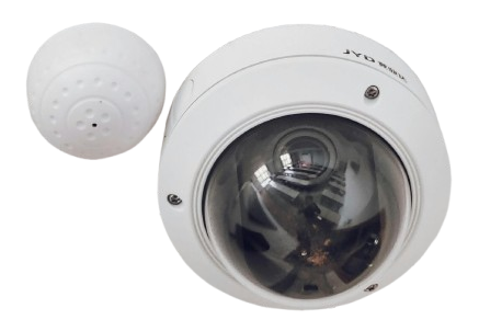 A white security camera is mounted to a wall.