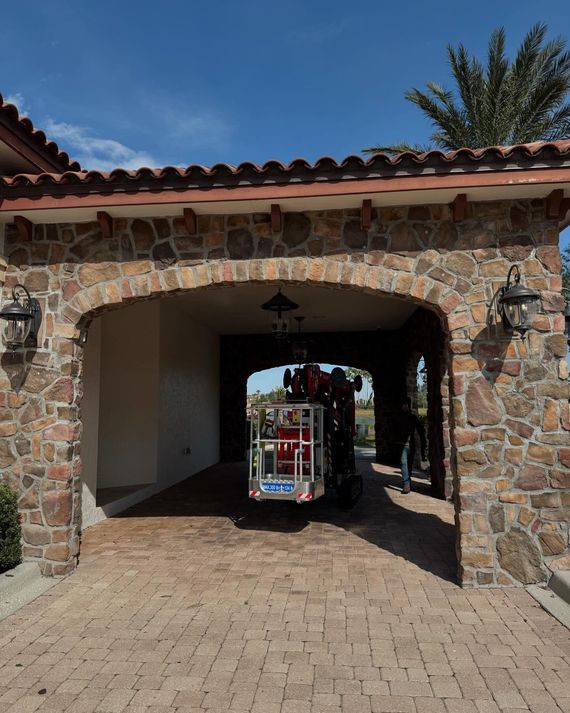 Stone archway with a colorful small train cart passing through a shaded passage outdoors
