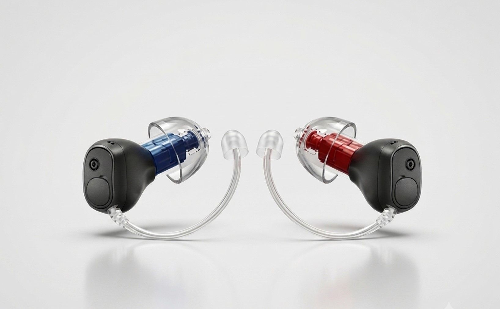 Two transparent hearing aids, one blue and one red, angled toward each other on a white background
