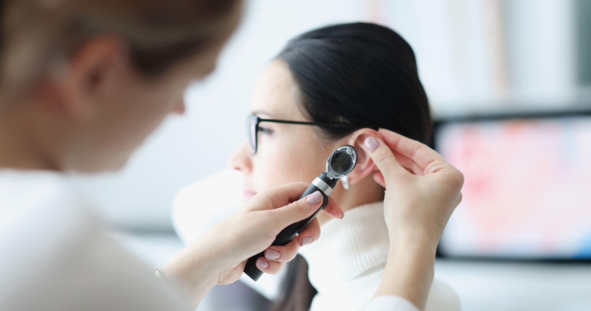 Eye exam with an optometrist adjusting a phoropter on a patient wearing glasses