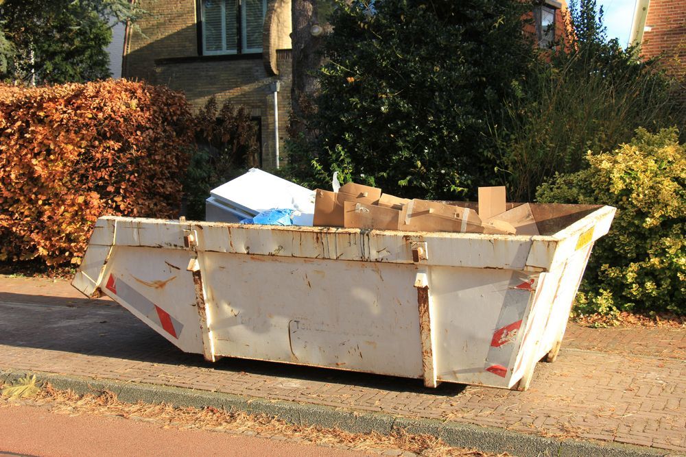 White Dumpster on a Sidewalk, Overflowing With Cardboard — Mount Isa Skips In Cloncurry, QLD