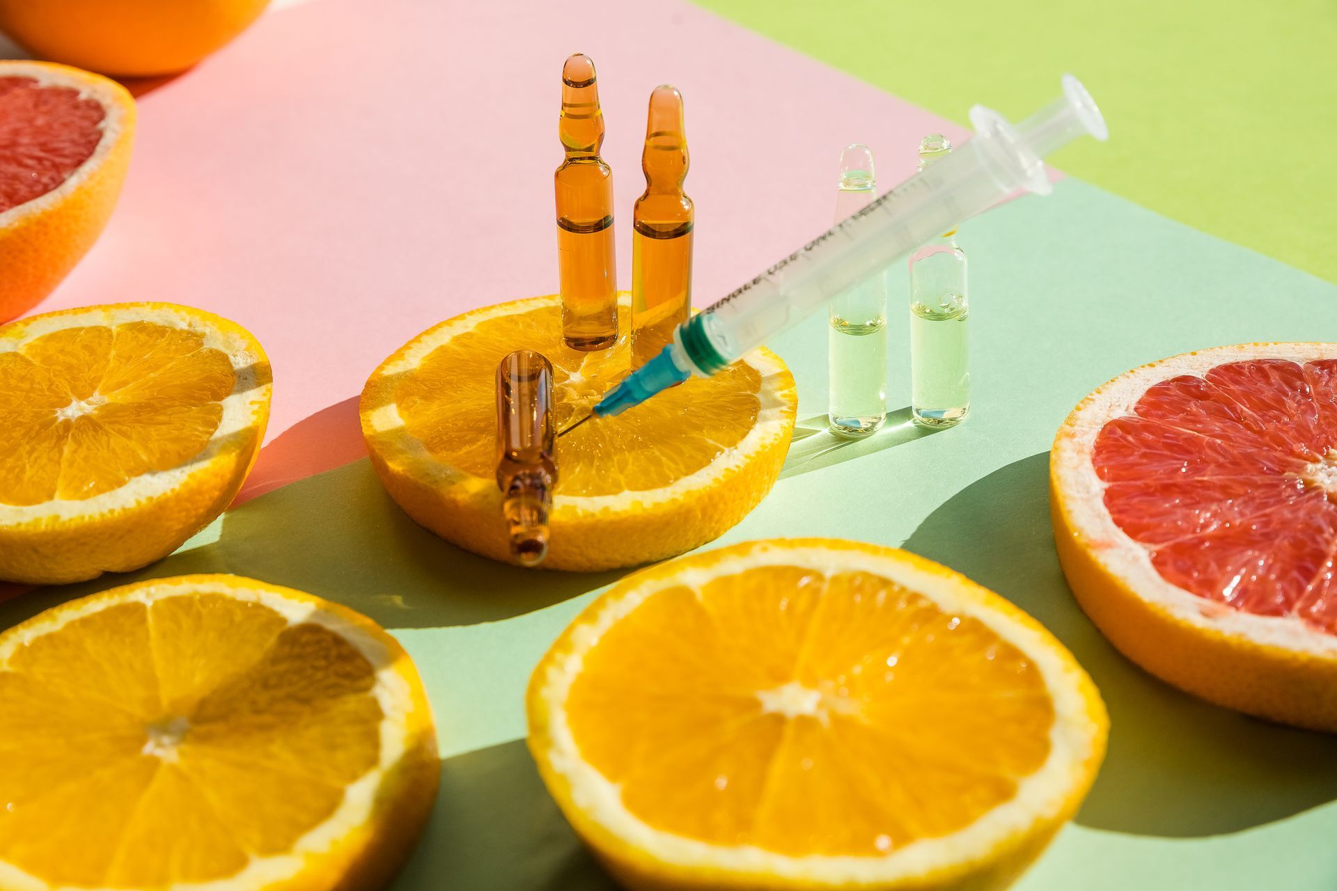 A syringe is being inserted into an orange slice.