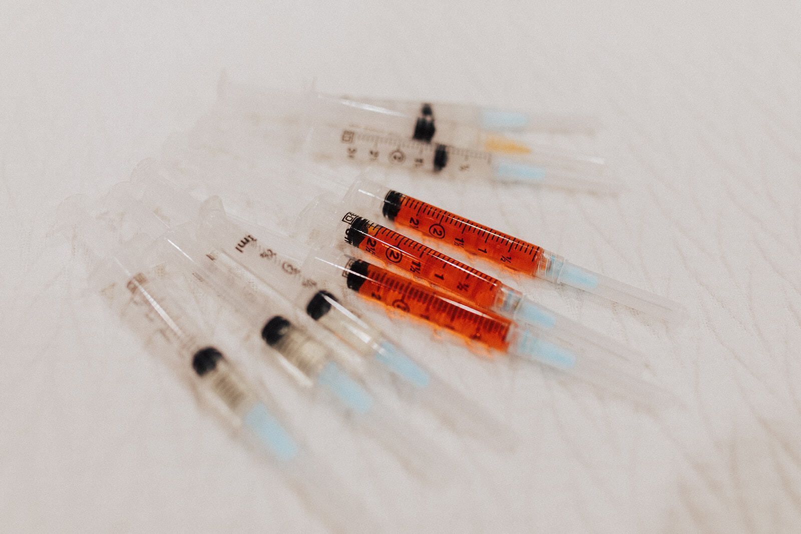 A group of syringes filled with red liquid are sitting on a table.