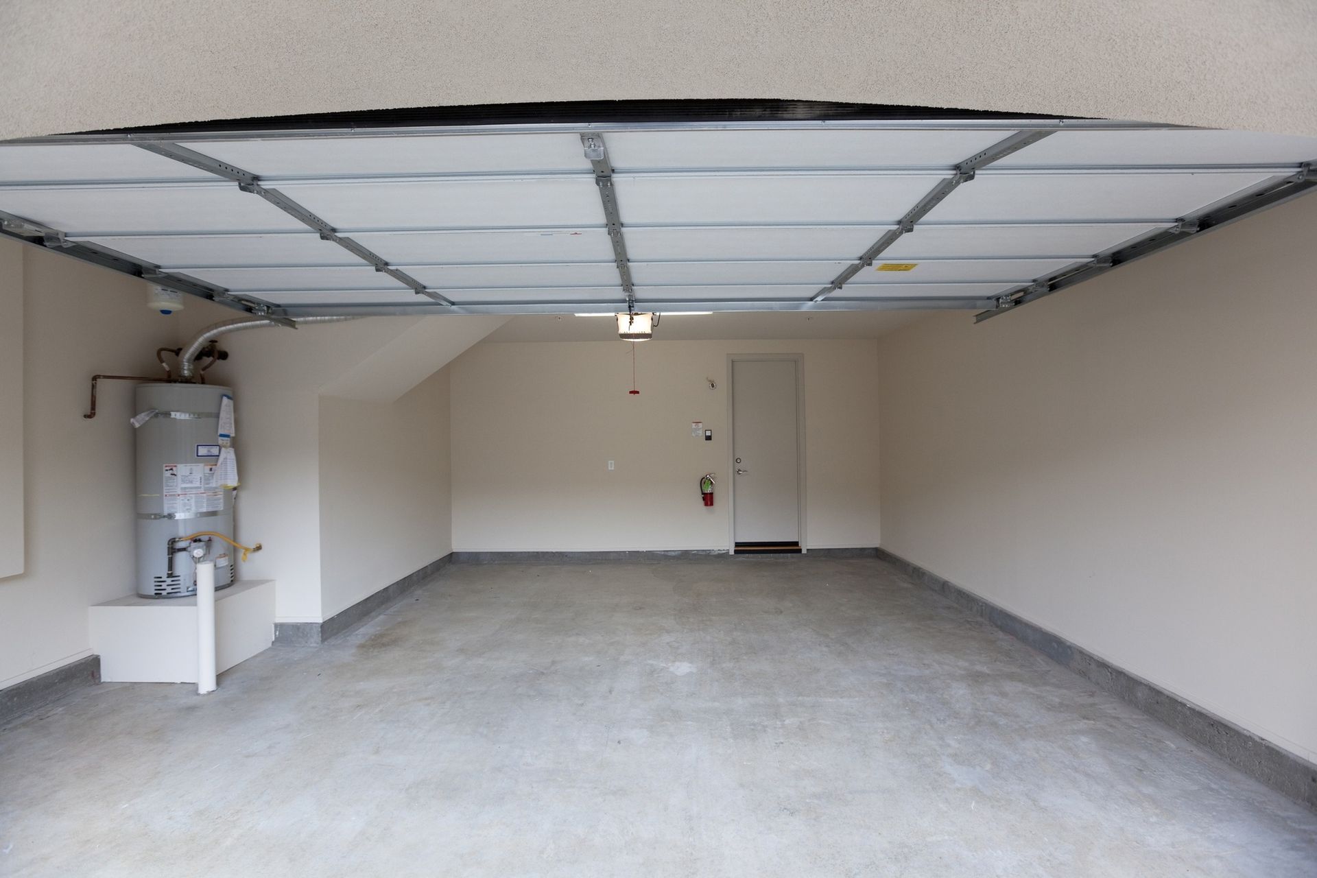 An empty garage with a heater and a door
