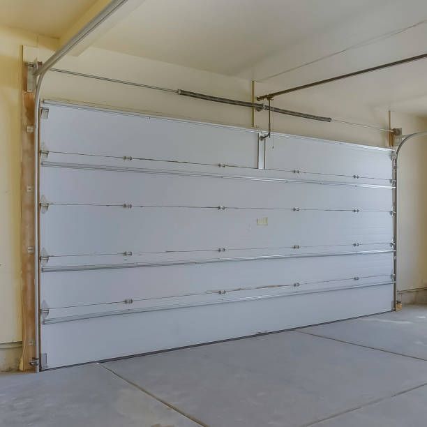 A large white garage door is open in a garage
