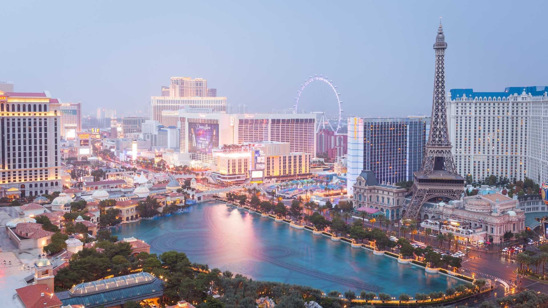 An aerial view of las vegas at night with the eiffel tower in the background.