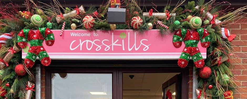 A festive storefront decorated for Christmas with a sign that reads 
