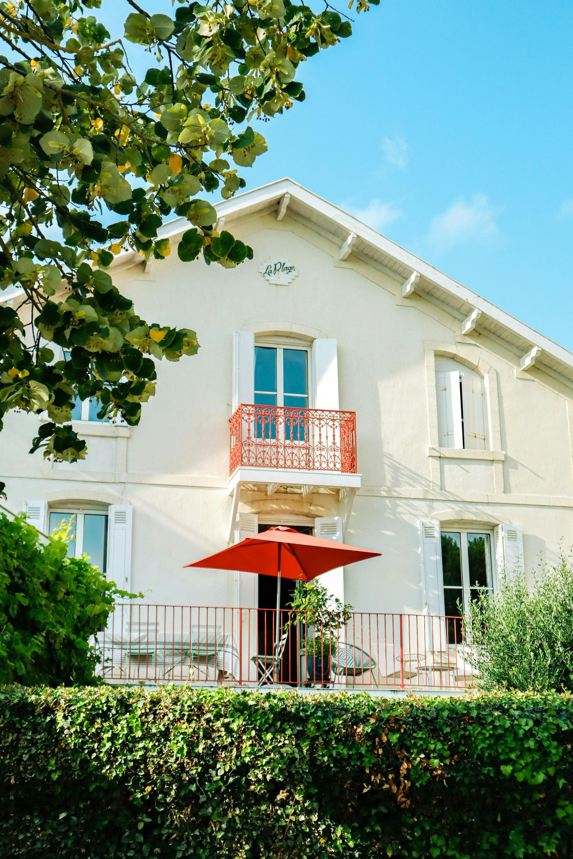 Une maison blanche avec un parapluie rouge devant à Fécamp en Normandie