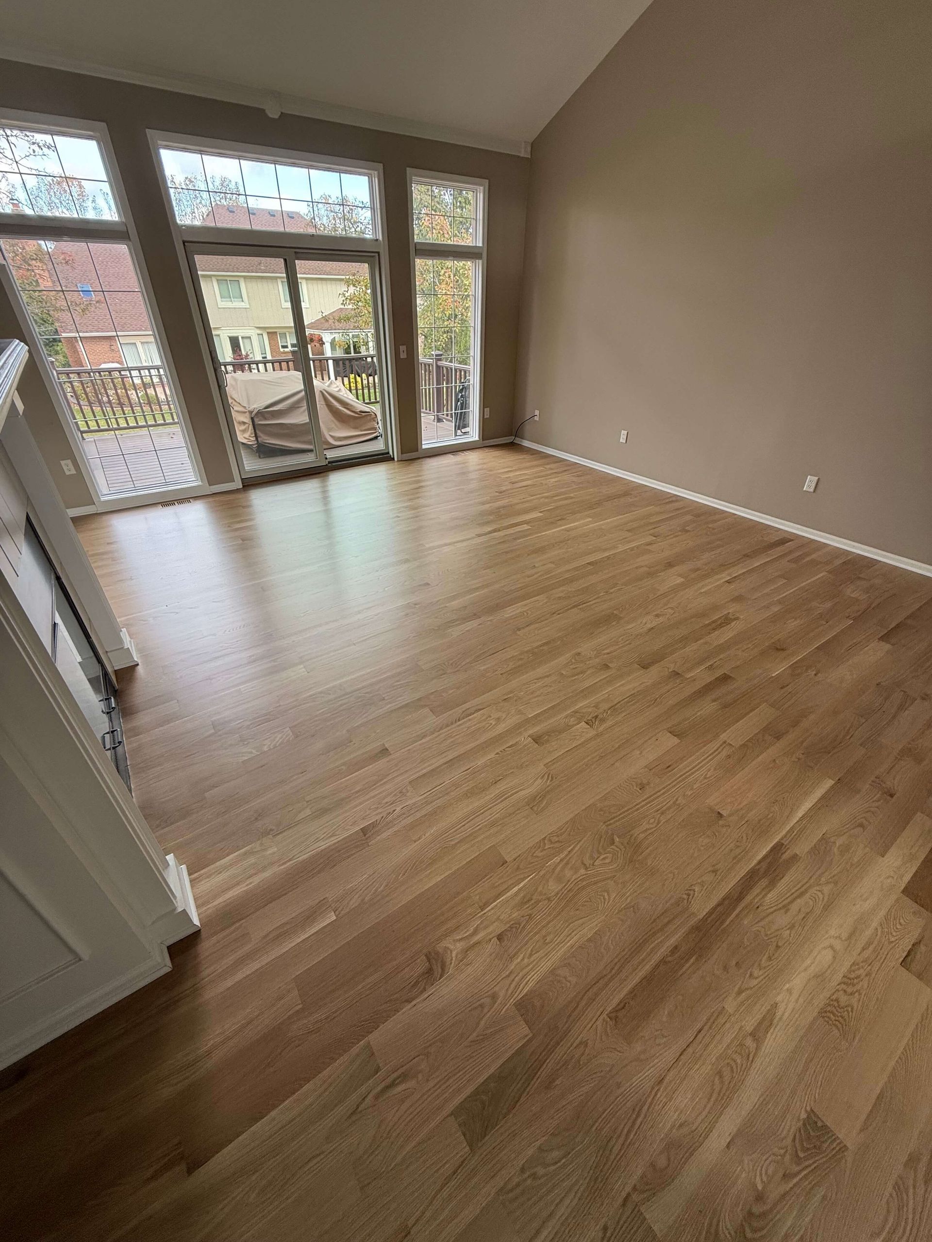 Room with hardwood floors and large glass doors opening to a balcony.