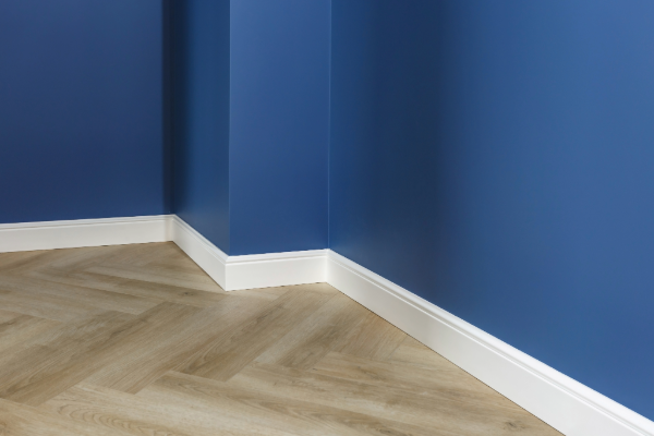 A close up of a white door frame on a blue wall.