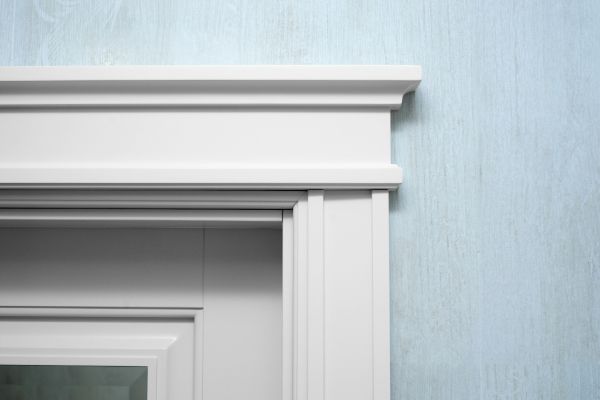A close up of a white door frame on a blue wall.