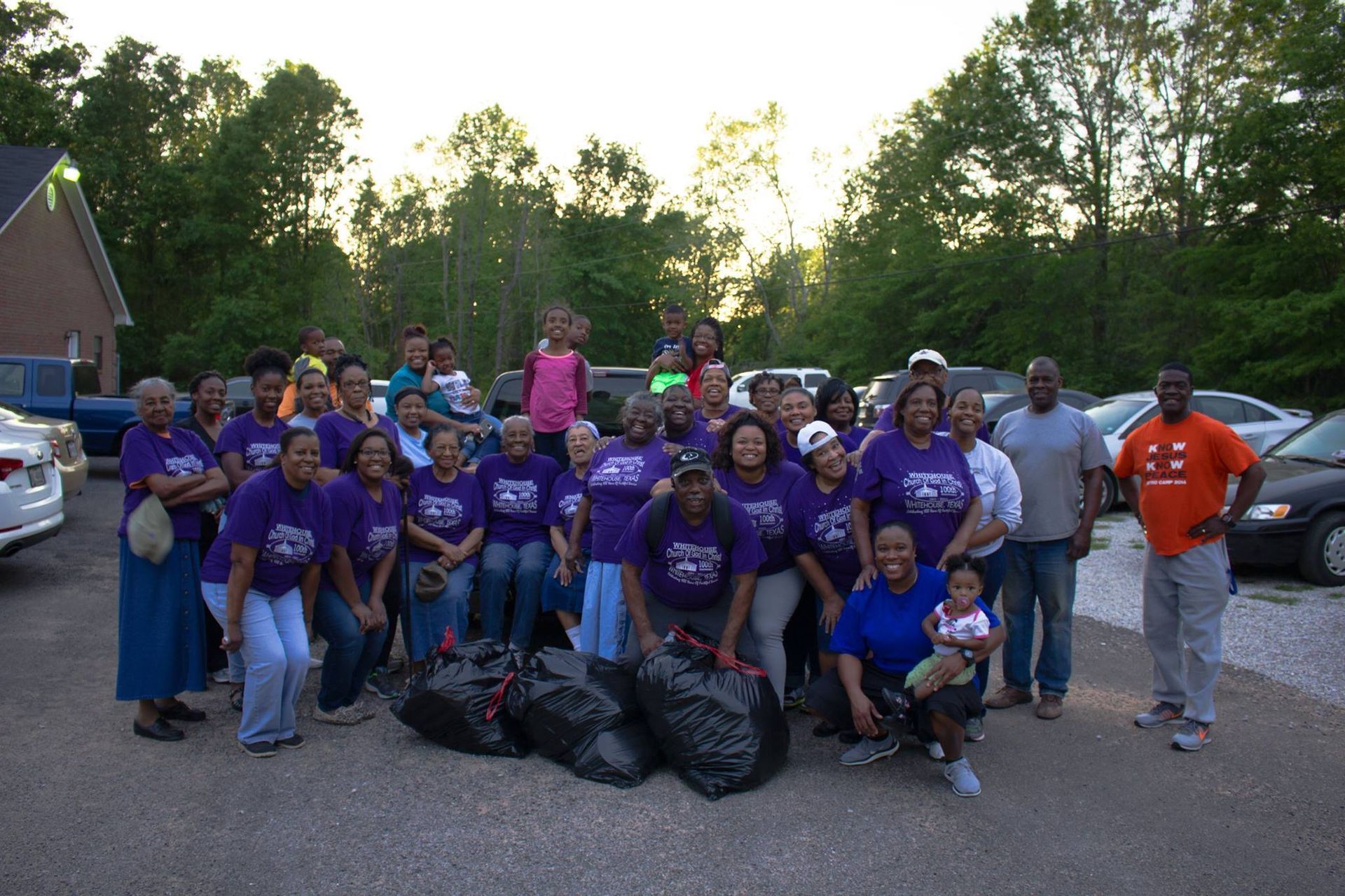 A group of people wearing purple shirts are posing for a picture