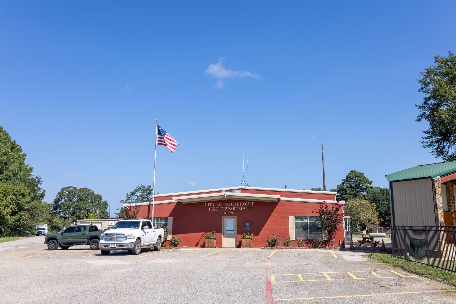 A red building with a white truck parked in front of it.