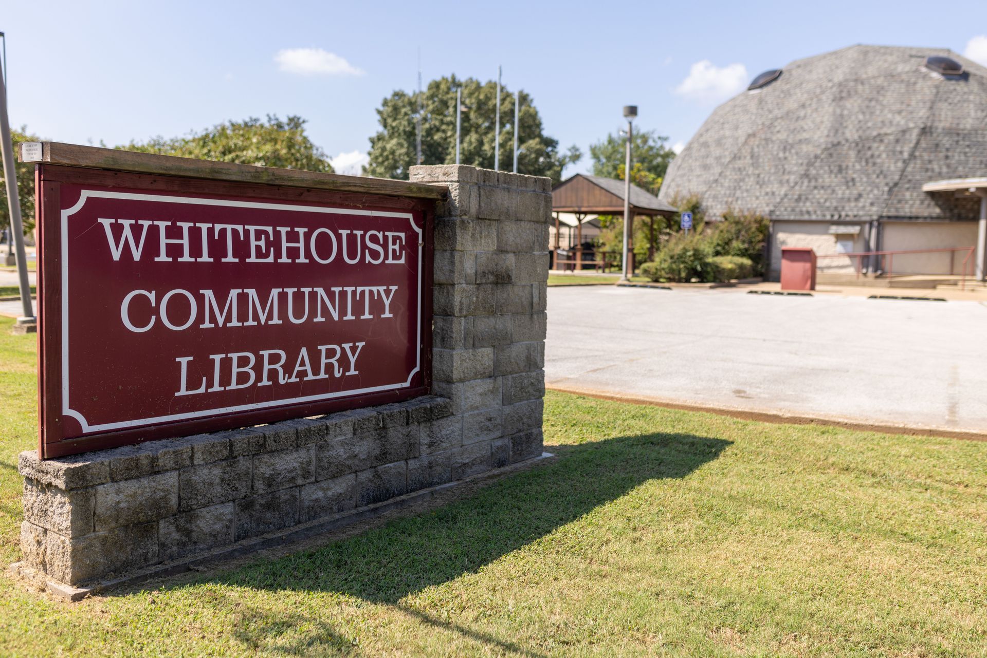 A red sign that says whitehouse community library on it
