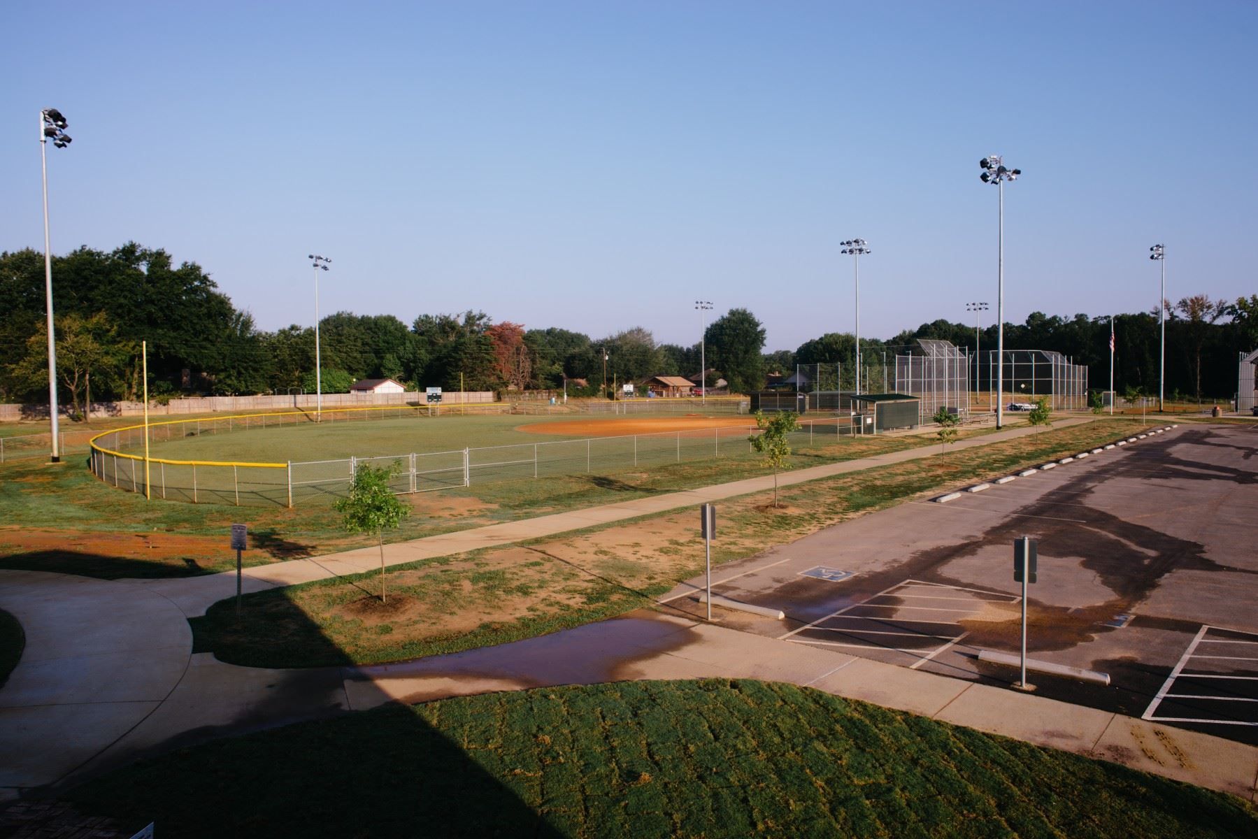 A view of a baseball field from a parking lot