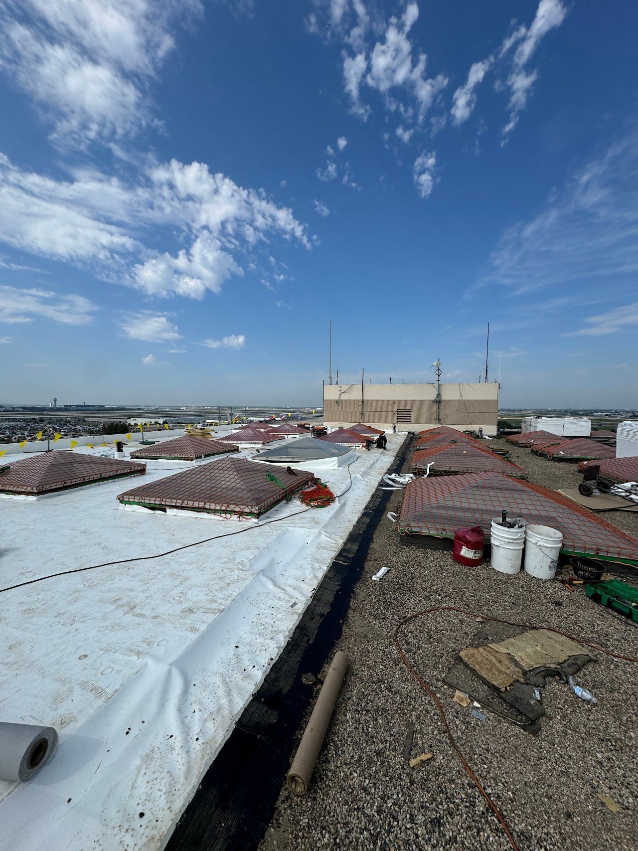 Commercial rooftop with skylights, membrane surfaces, and roofing materials.