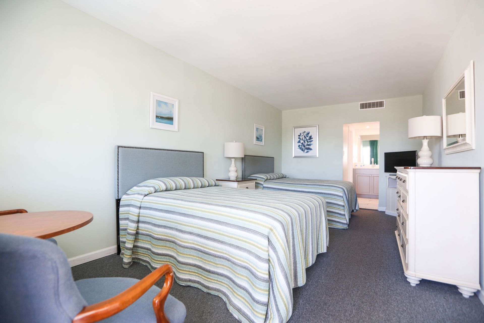 A hotel room with two beds and a chair