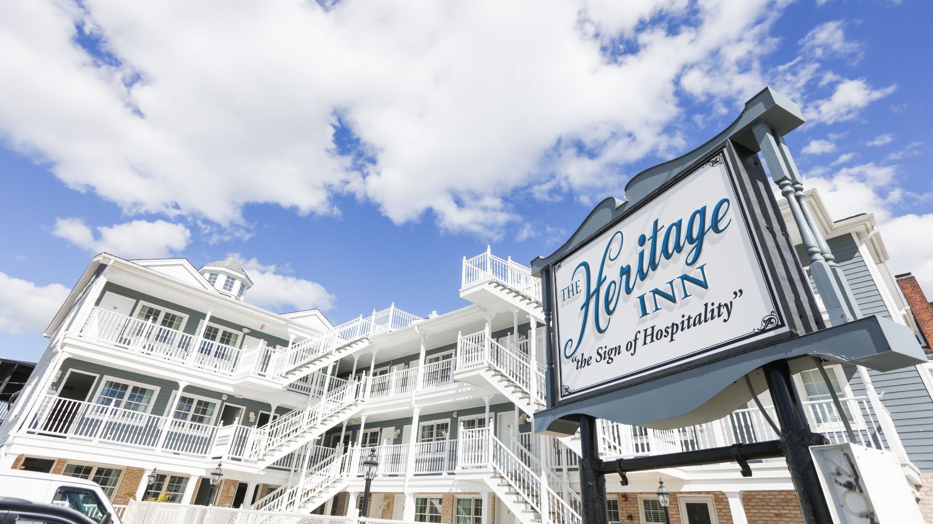 A large white building with a sign that says heritage inn on it.