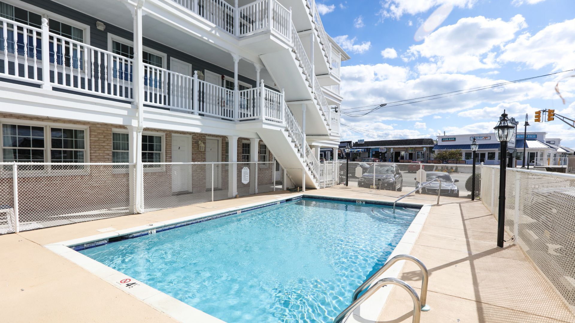There is a large swimming pool in front of a building.