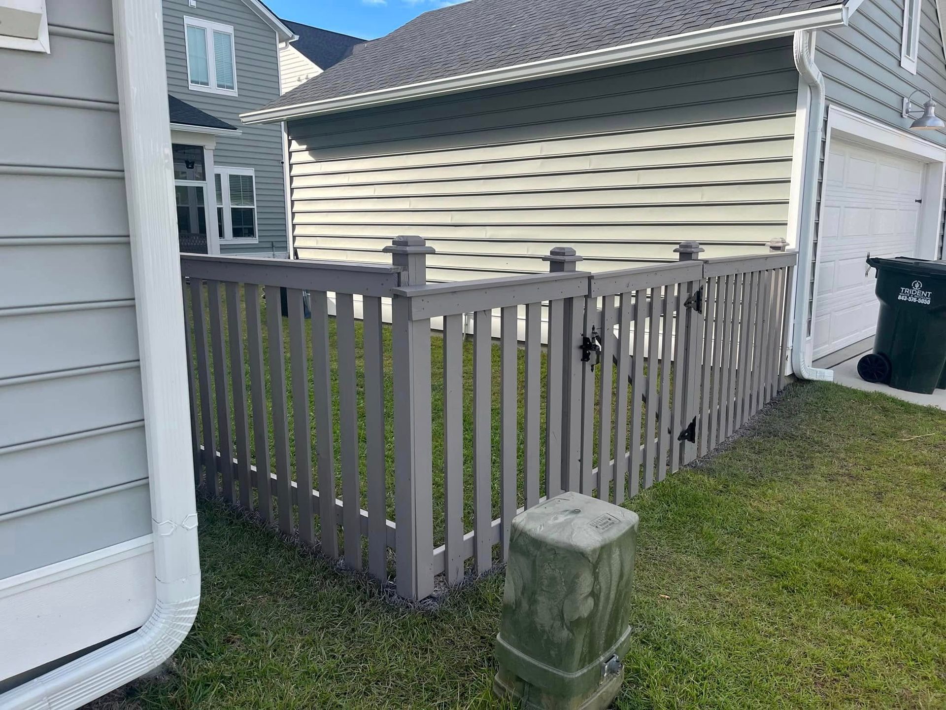 A wooden fence is sitting in front of a house.