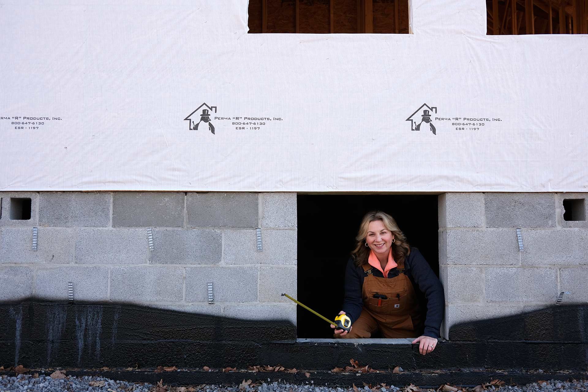 Collette Branham standing in a block wall opening at a TriStar Custom Homes construction site in Chattanooga