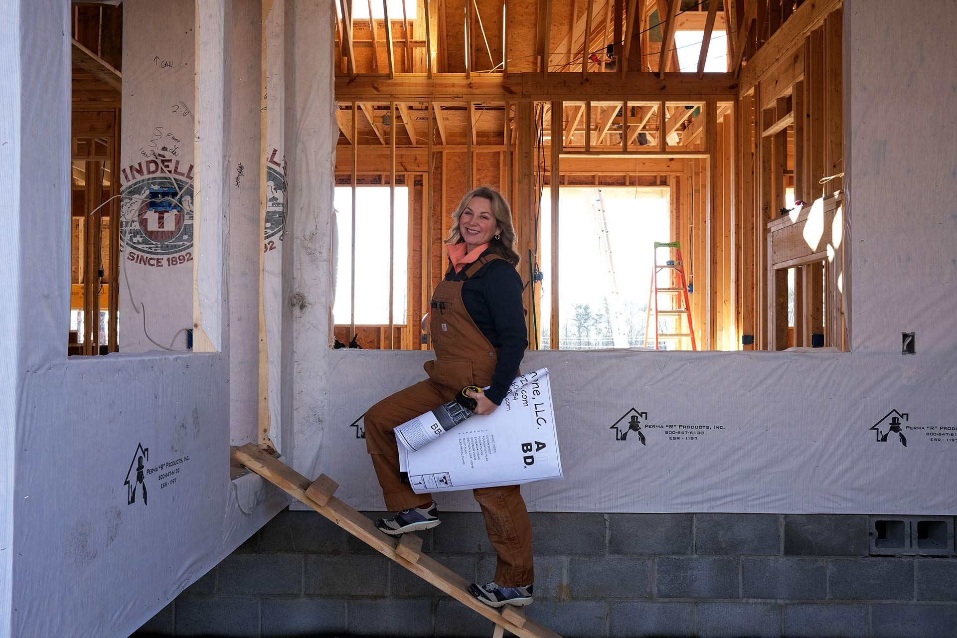Collette Branham, owner of TriStar Custom Homes, holding plans in a Chattanooga home under construction