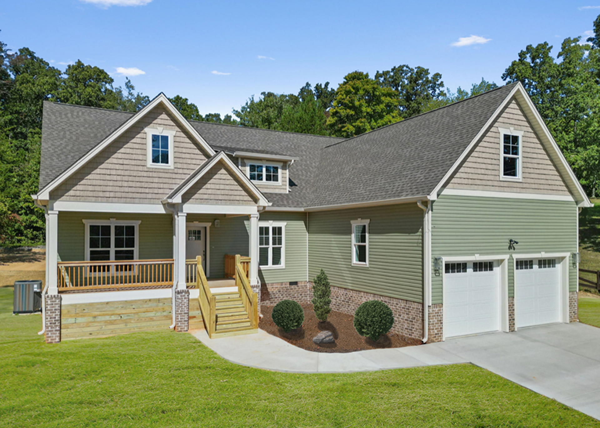 Green Craftsman-style home with brick and siding exterior, built by Tristar Custom Homes — custom home design services Chattanooga.