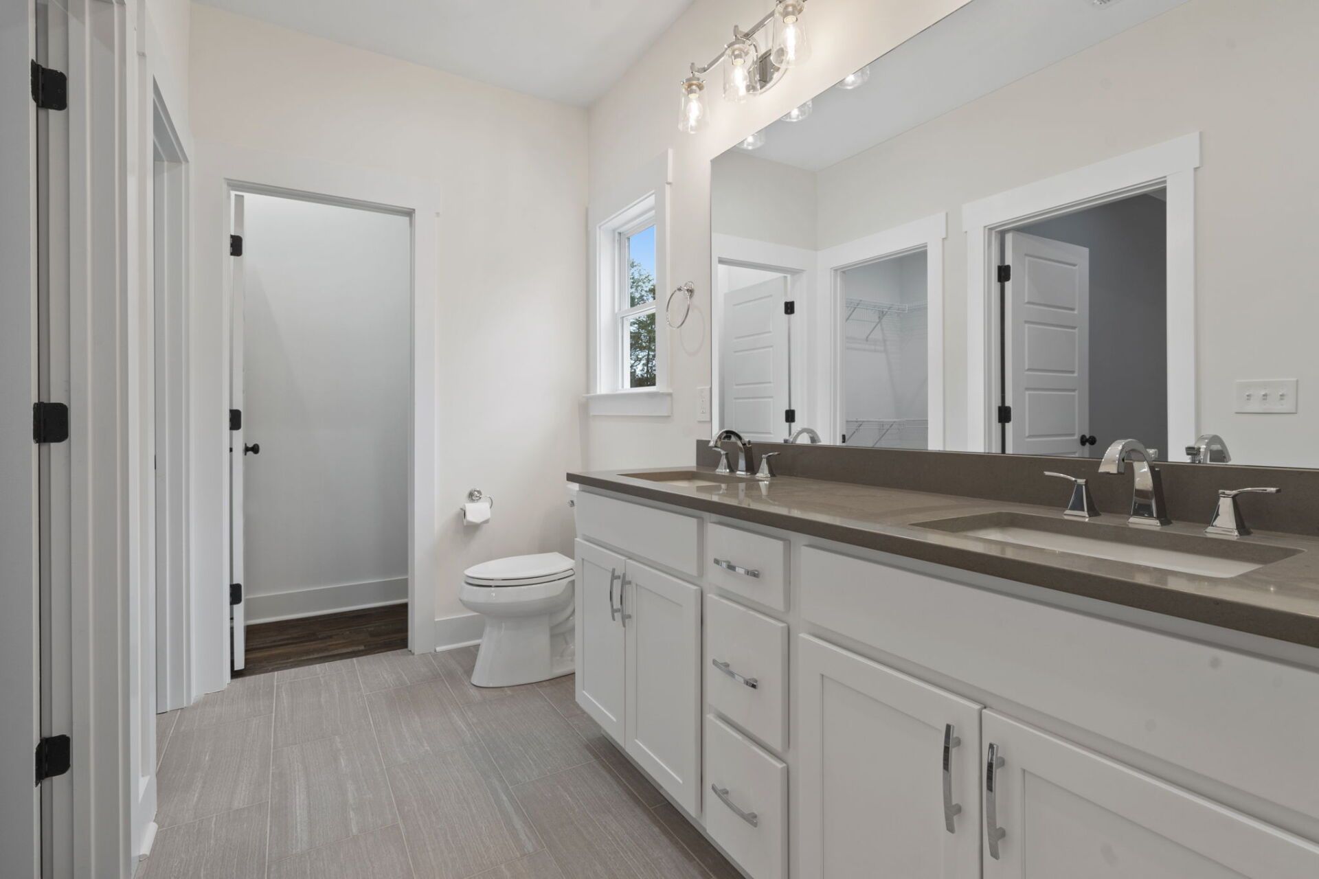 Modern bathroom with dual vanity, quartz countertops, and brushed nickel fixtures in newly built Chattanooga home.