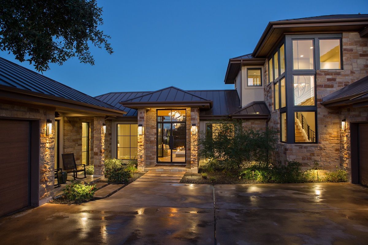 Stone house exterior with lit entryway at dusk