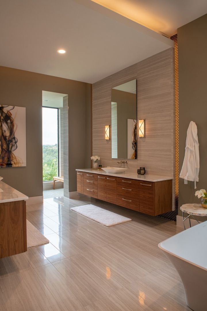 Modern bathroom with wood vanity, beige tile, large mirror, and open window.