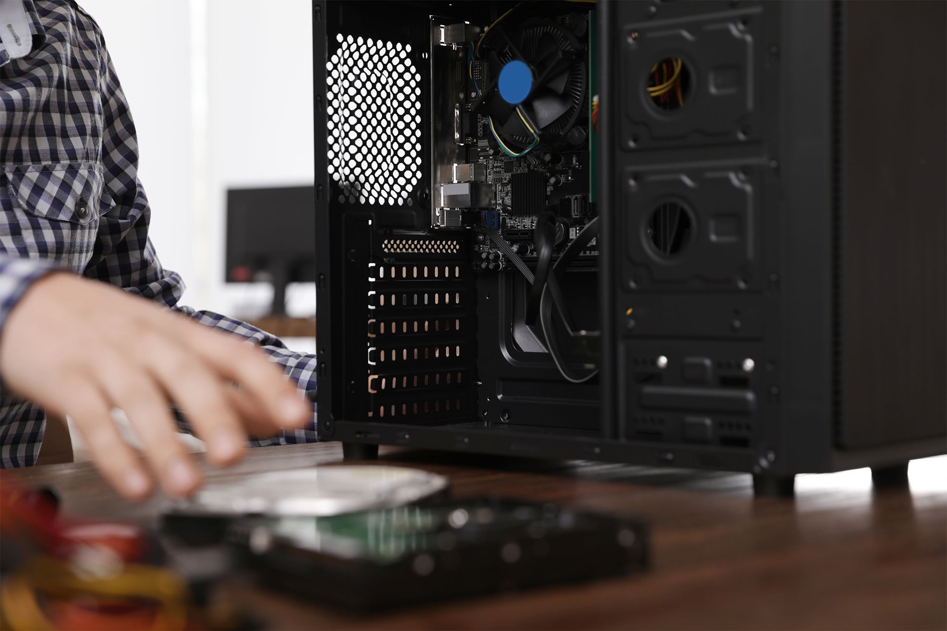 A man is installing a hard drive into a computer case