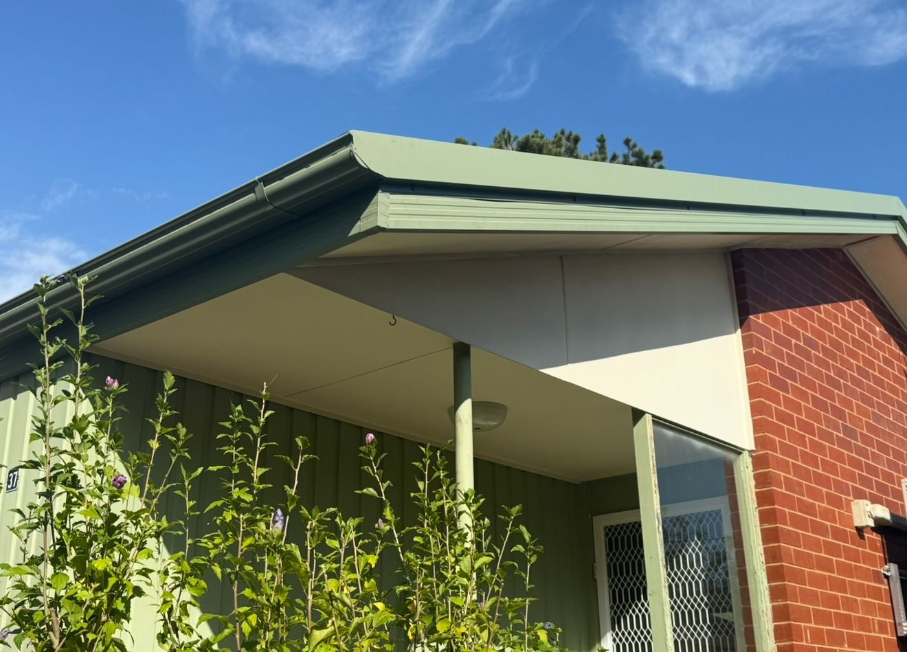 A Brick Building With a Green Gutter — CBR Maintenance In Queanbeyan, NSW