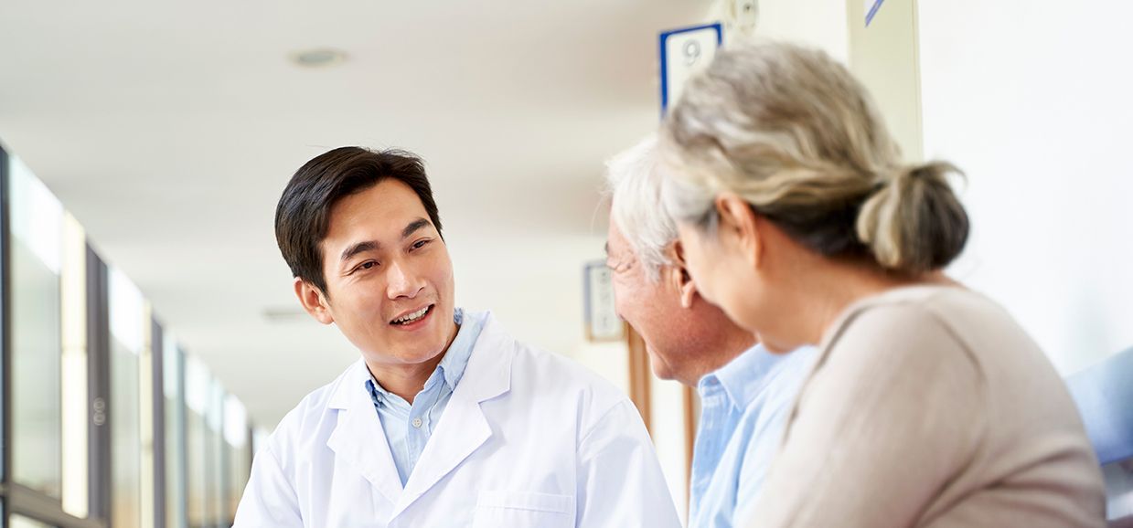 Doctor speaking with a patient in a bright clinic hallway