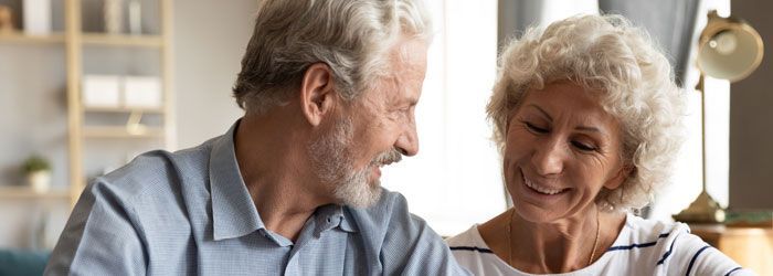 A man and a woman are looking at each other in a living room.