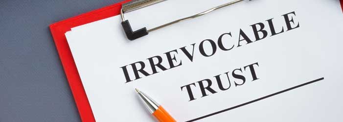 A clipboard with the words irrevocable trust written on it.
