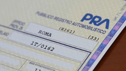 Primo piano di un documento di immatricolazione di un veicolo con il logo della PRA e i dati scritti a mano.