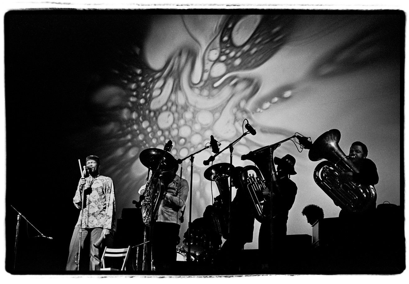 A black and white photo of a band on stage