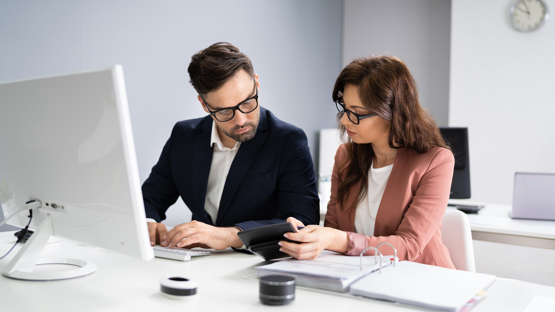 un homme et une femme regardent un écran d' ordinateur
