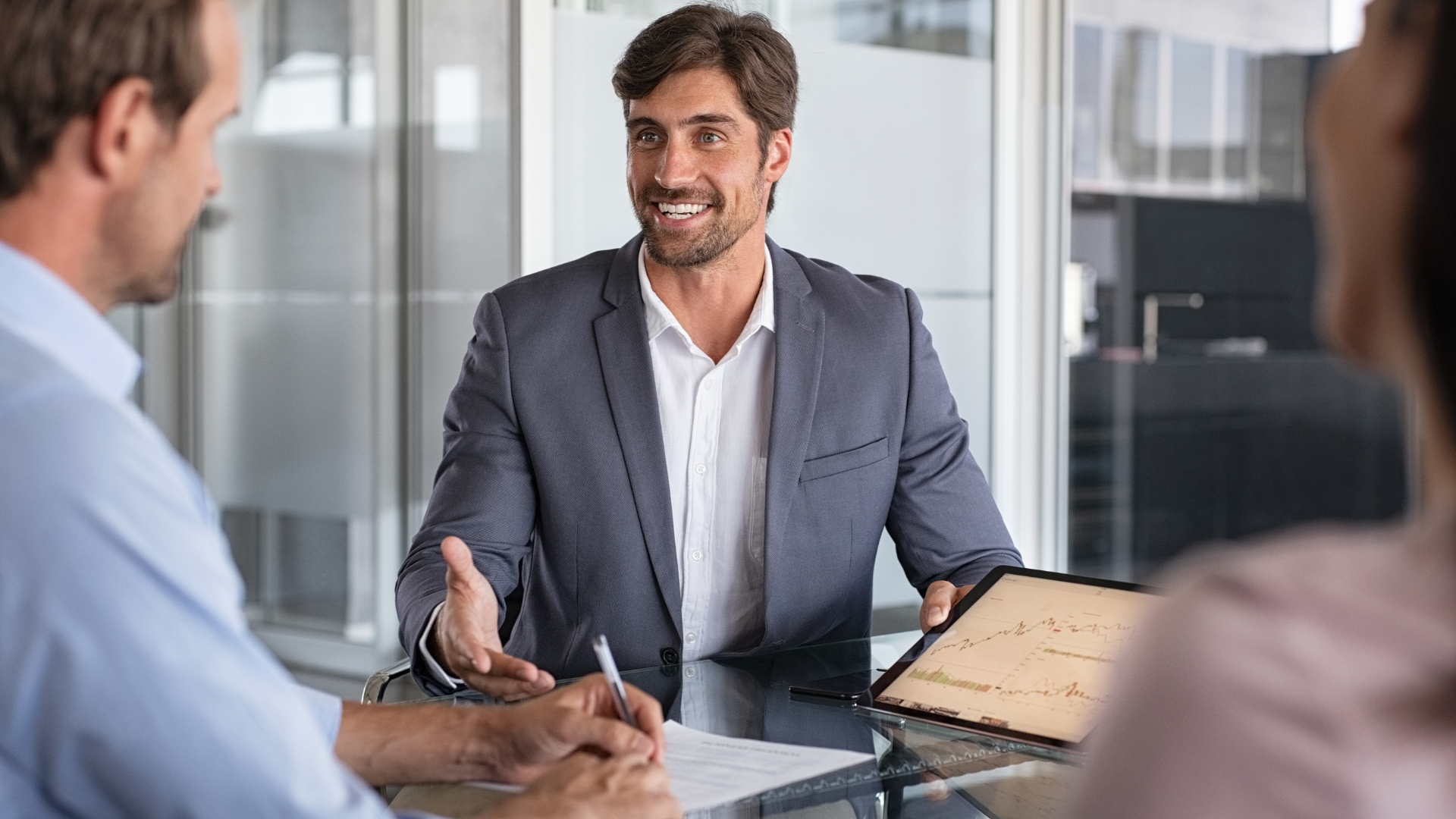 un homme sourit tout en tenant une tablette avec un graphique sur elle