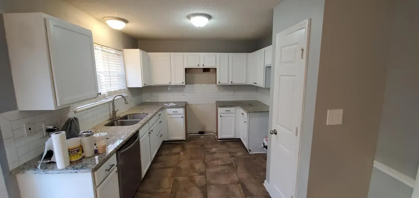 A kitchen with white cabinets and stainless steel appliances.