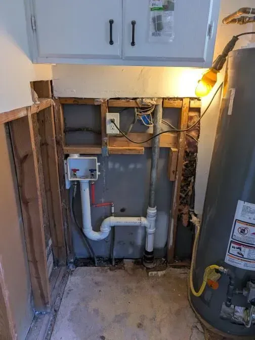 A bathroom with a water heater and a sink.