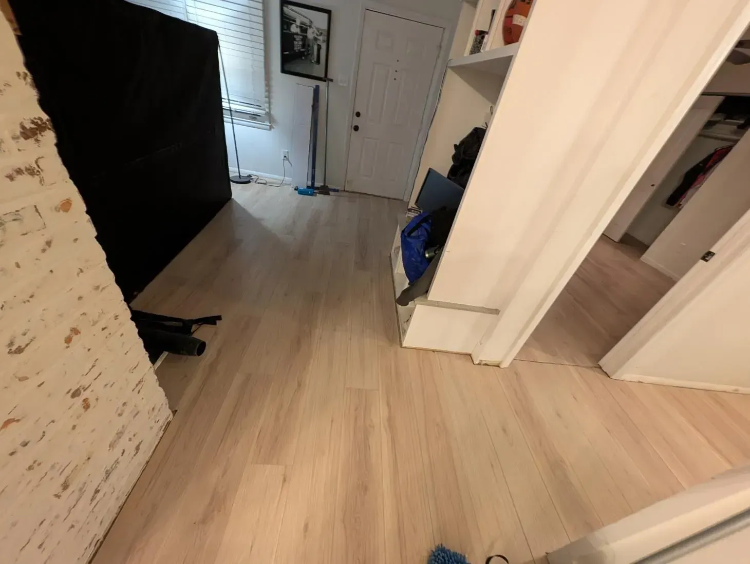 A hallway with hardwood floors and a picture on the wall