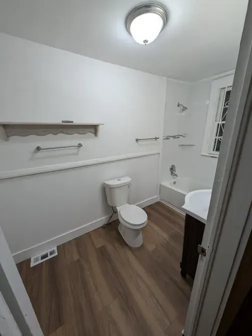 A bathroom with a toilet , sink and bathtub.