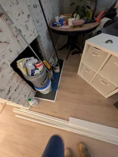 A person standing in front of a mirror in a messy room