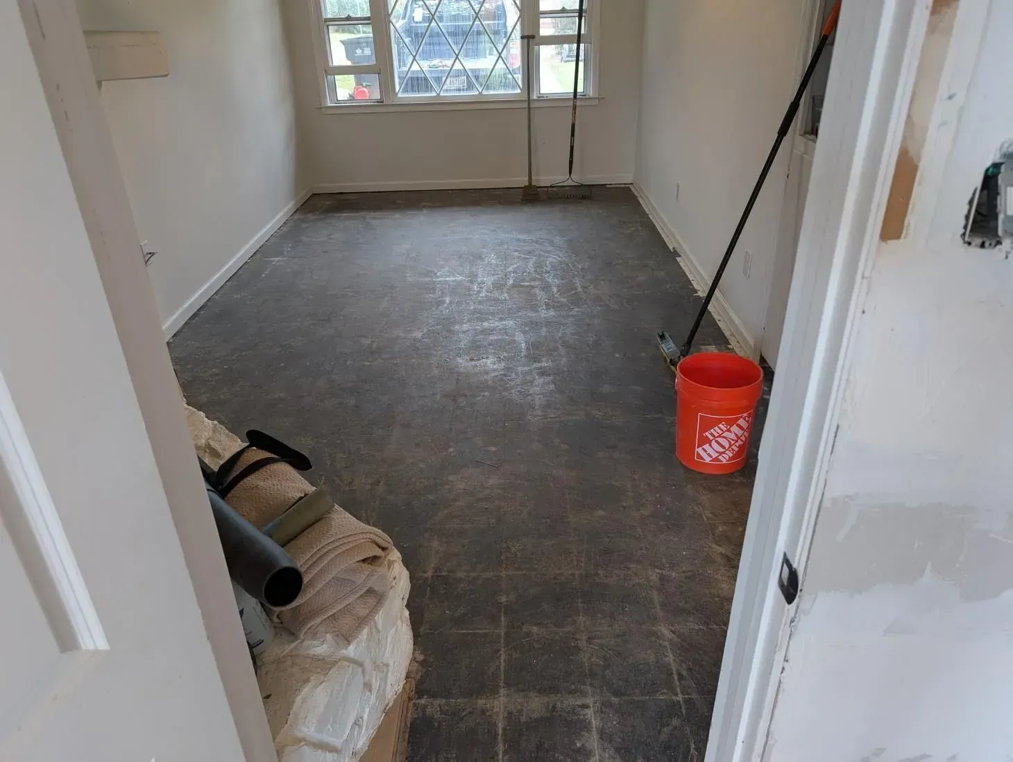 A room with a mop and bucket on the floor.
