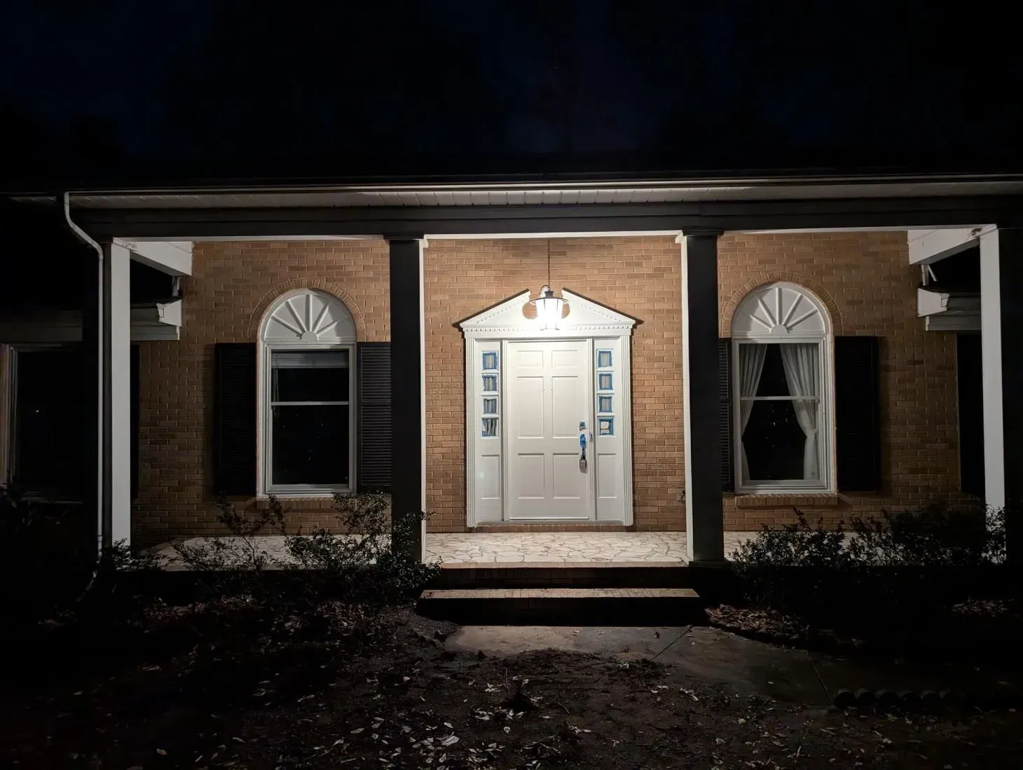 The front door of a house is lit up at night.