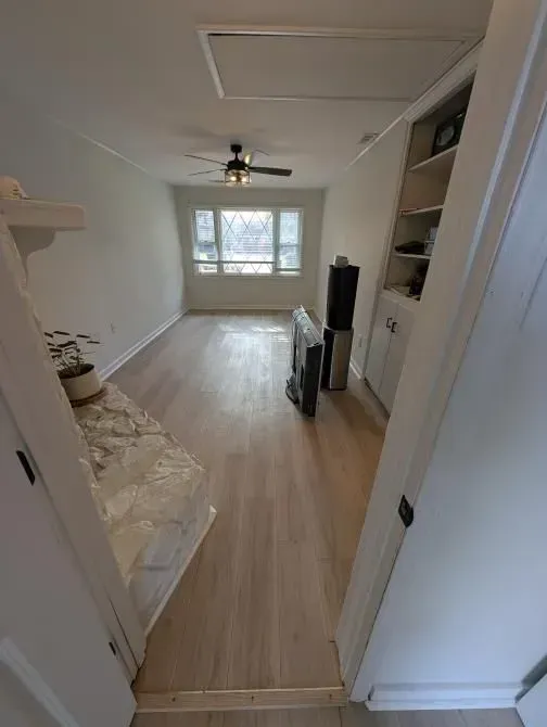 A living room with hardwood floors and a ceiling fan.