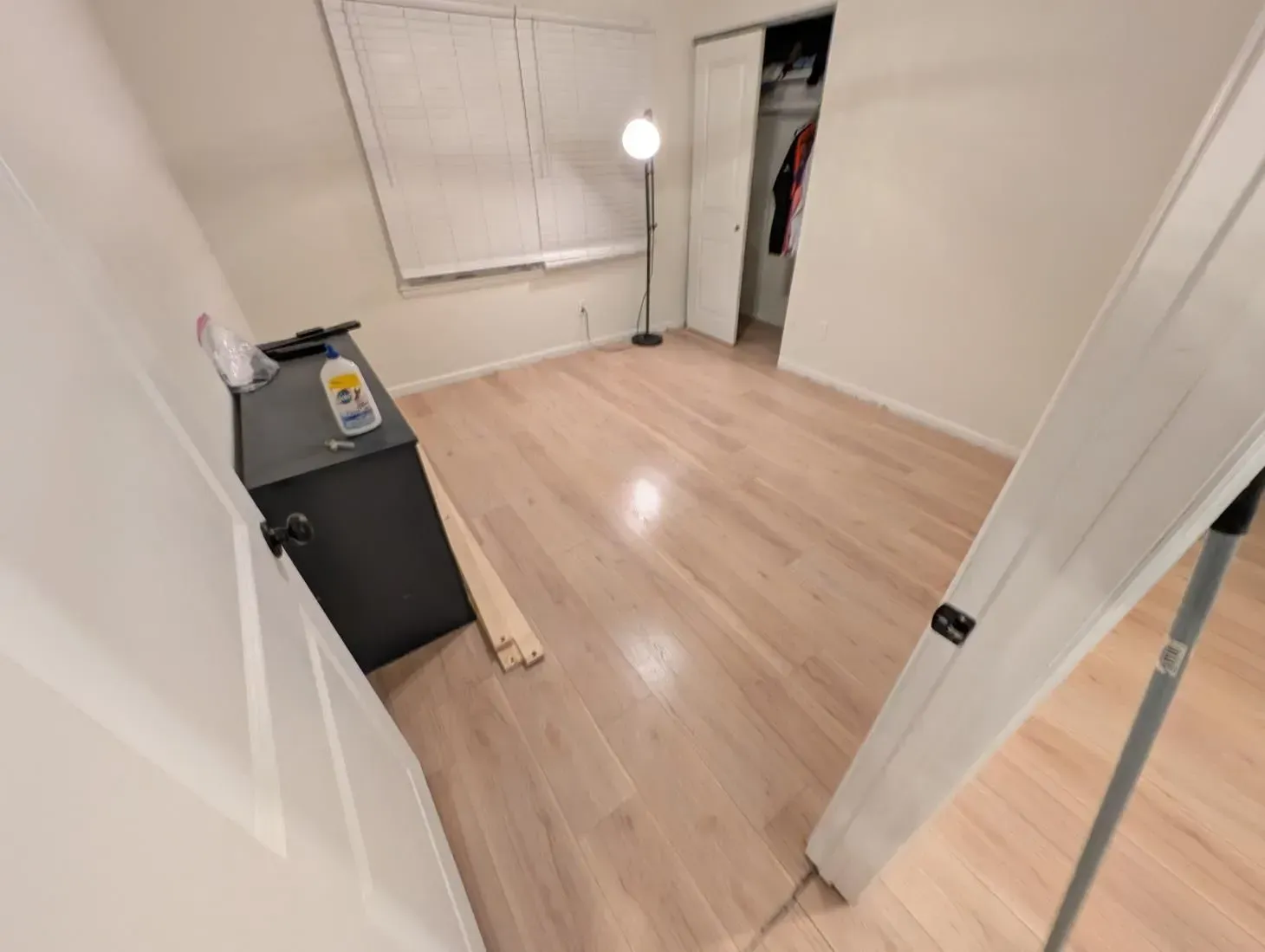 An empty bedroom with hardwood floors and a window