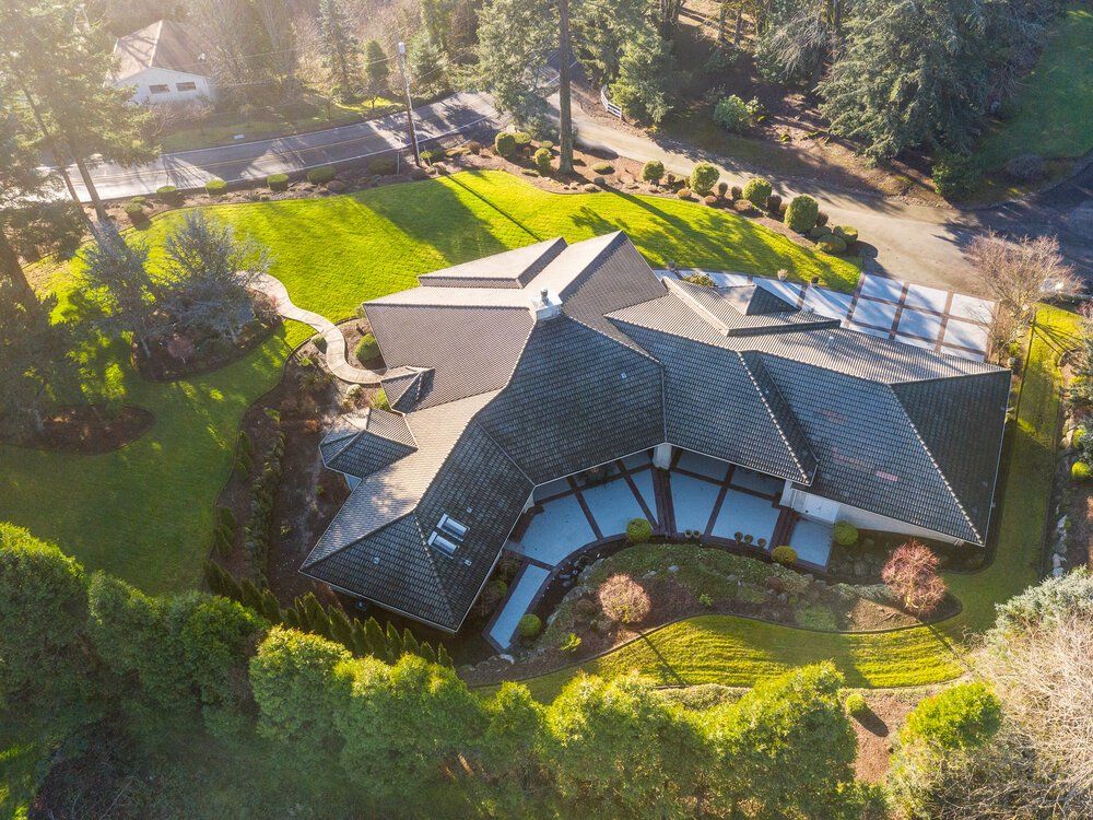 Drone photo of a single story house and grass surrounding.