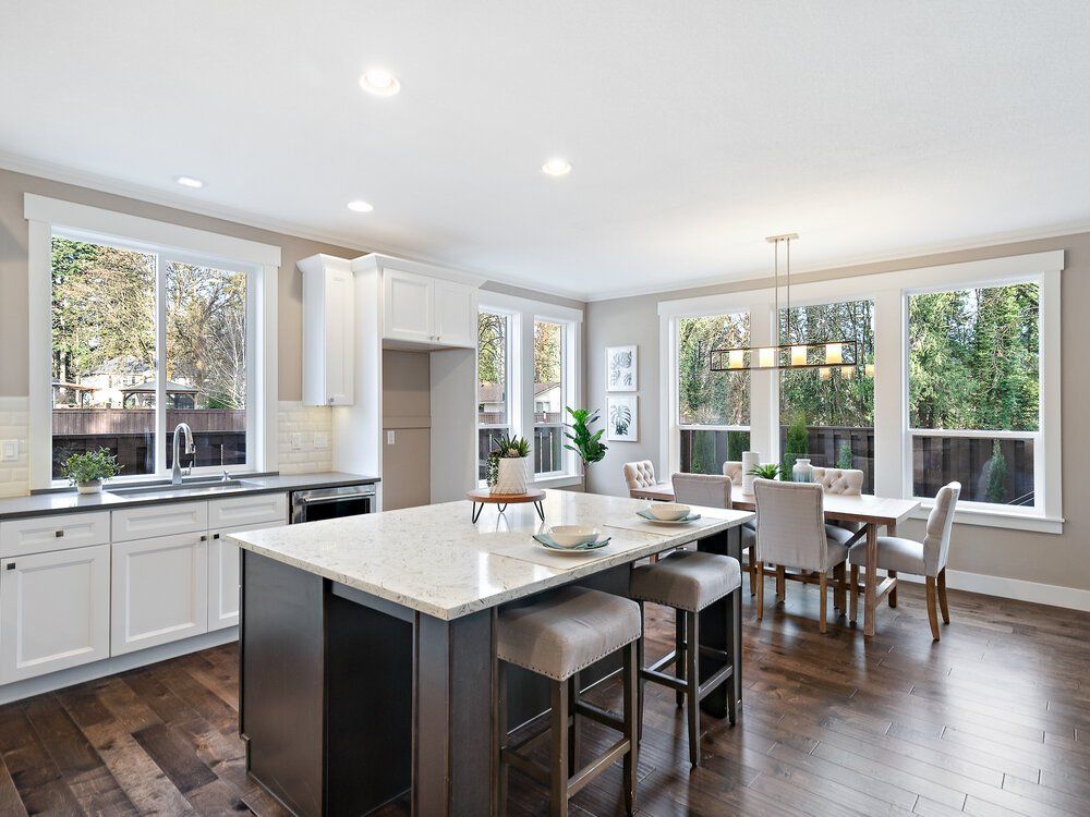 Photo of a big kitchen with a center island and barstools.